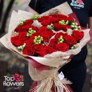 Round bouquet of 31 red roses with greenery