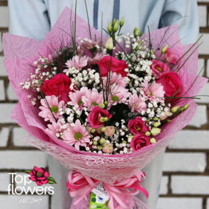 Детайл на букет Бонбонена целувка с розови цветя и ефирна декорация