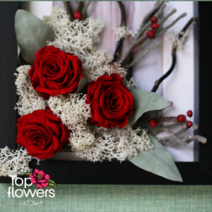 Detail of a living picture with red roses and natural materials