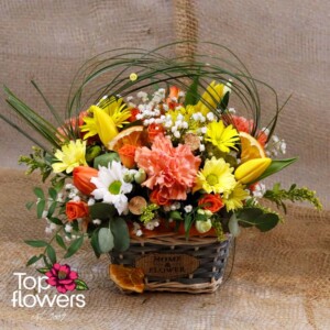 “Cuba” – colorful flower arrangement in a wooden basket by Top Flowers
