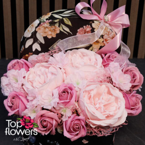 Close-up of a satin ribbon and floral box filled with soap roses.