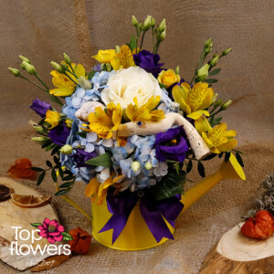 Arrangement with rose and hydrangea in a yellow metal watering can