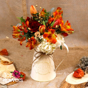Flowers in orange and red shades with hydrangea and greenery