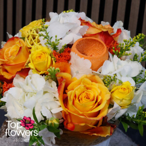 Детайлна снимка на аранжировка с рози, мини рози, хортензия и цитрусова декорация