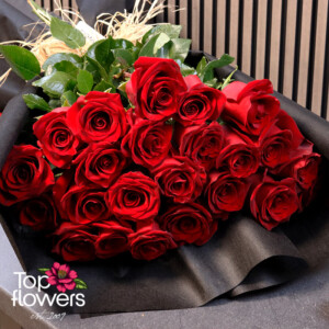 red roses in stylish black floral wrapping