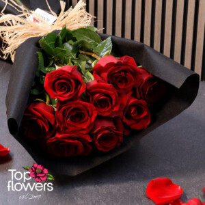 Bouquet of red Explorer roses in black wrapping