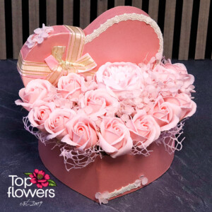 Close-up of premium soap roses and dehydrated hydrangea in a romantic heart-shaped floral arrangement.